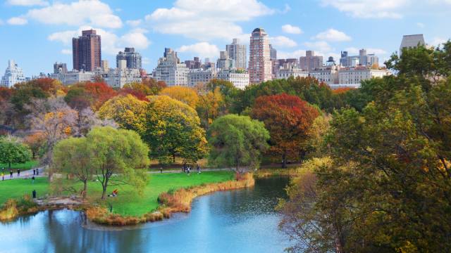 New York City Manhattan Central Park panorama in Autumn lake with skyscrapers and colorful trees with reflection.