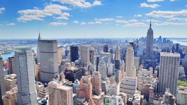  New York City Manhattan midtown aerial panorama view with skyscrapers and blue sky in the day.