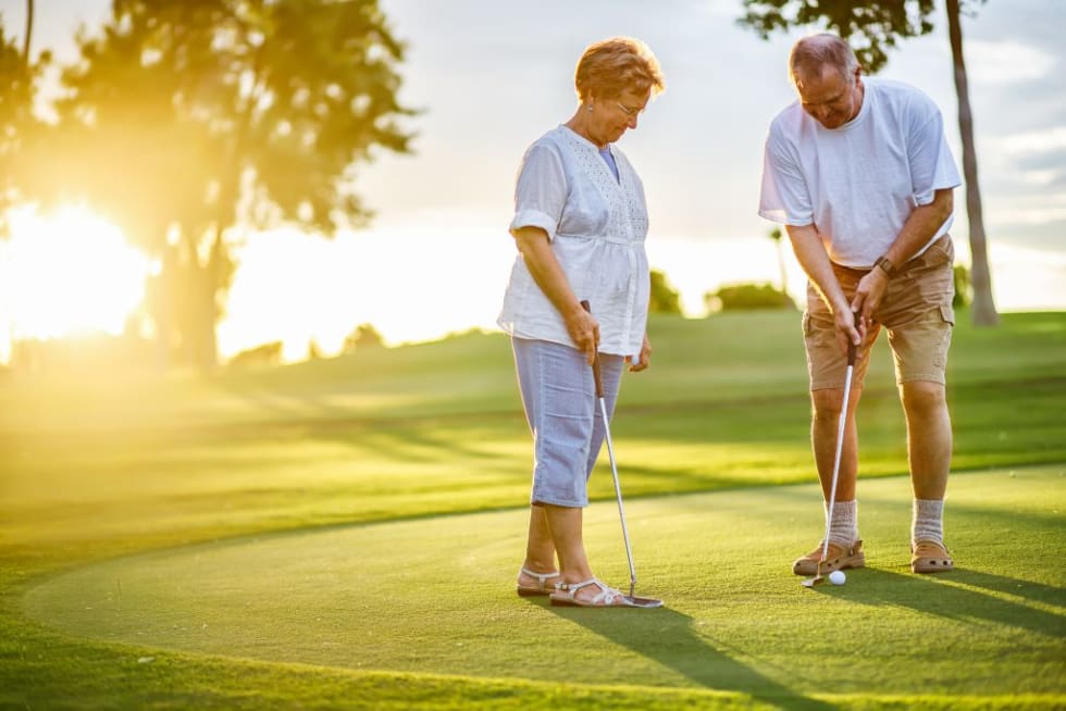 an older couple playing golf
