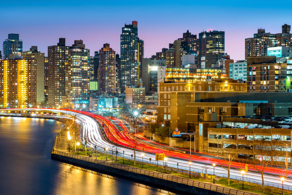  East Harlem neighborhood skyline with rush hour traffic on FDR drive, at dusk, in Manhattan, New York City