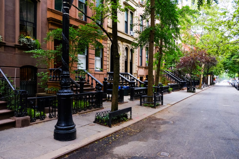 Beautiful buildings in Greenwich Village, Soho district. Entrance doors with stairs and trees, Manhattan New York.