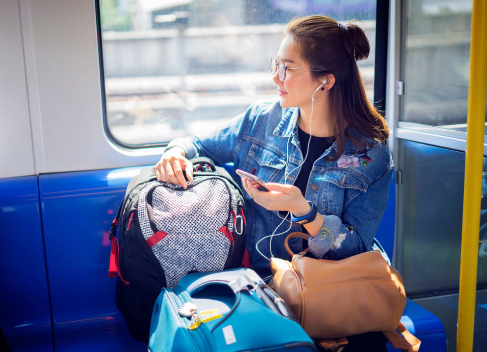 Young woman traveling looking out the window while sitting in the train