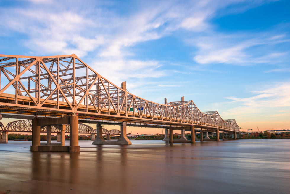 Louisville, Kentucky, USA with John F. Kennedy Memorial Bridge spanning the Ohio River at dusk.