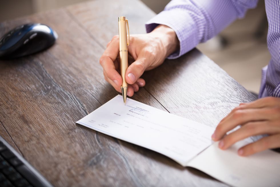 close up of someone signing a check