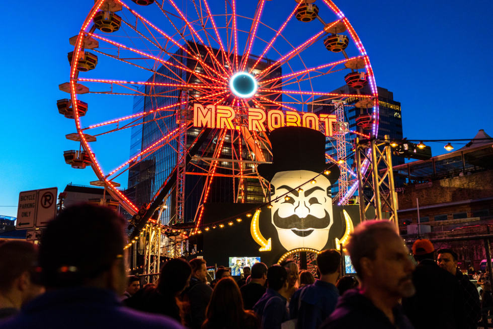 People walk by a carnival event for the USA television show Mr. Robot during SXSW