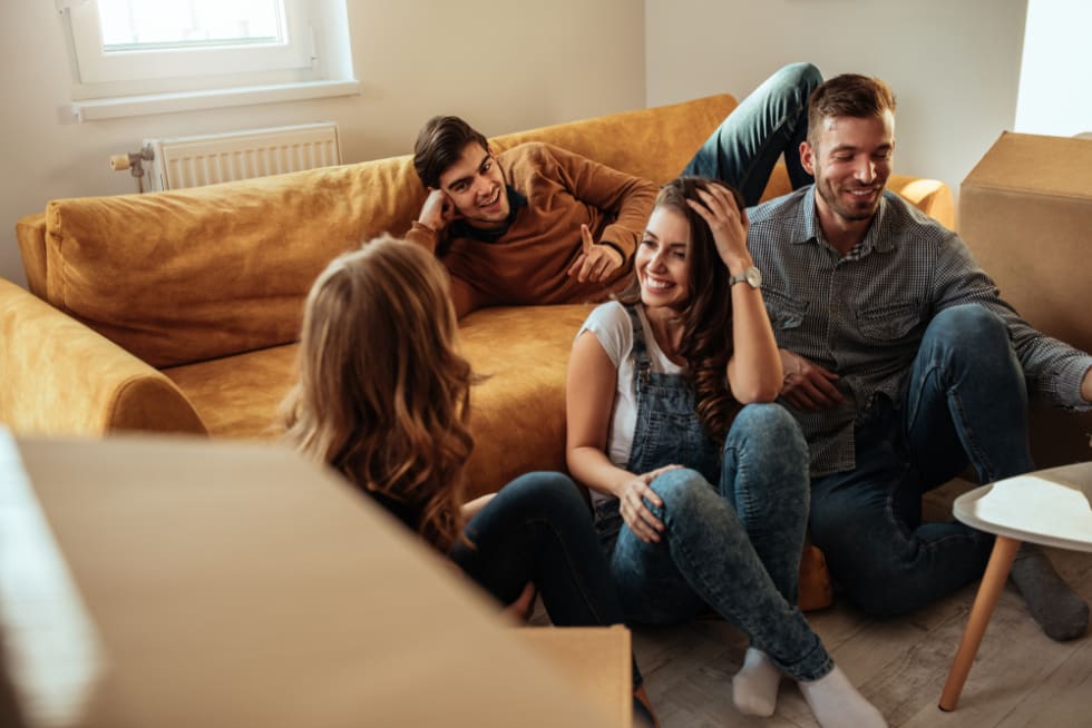 Roommates laughing by couch