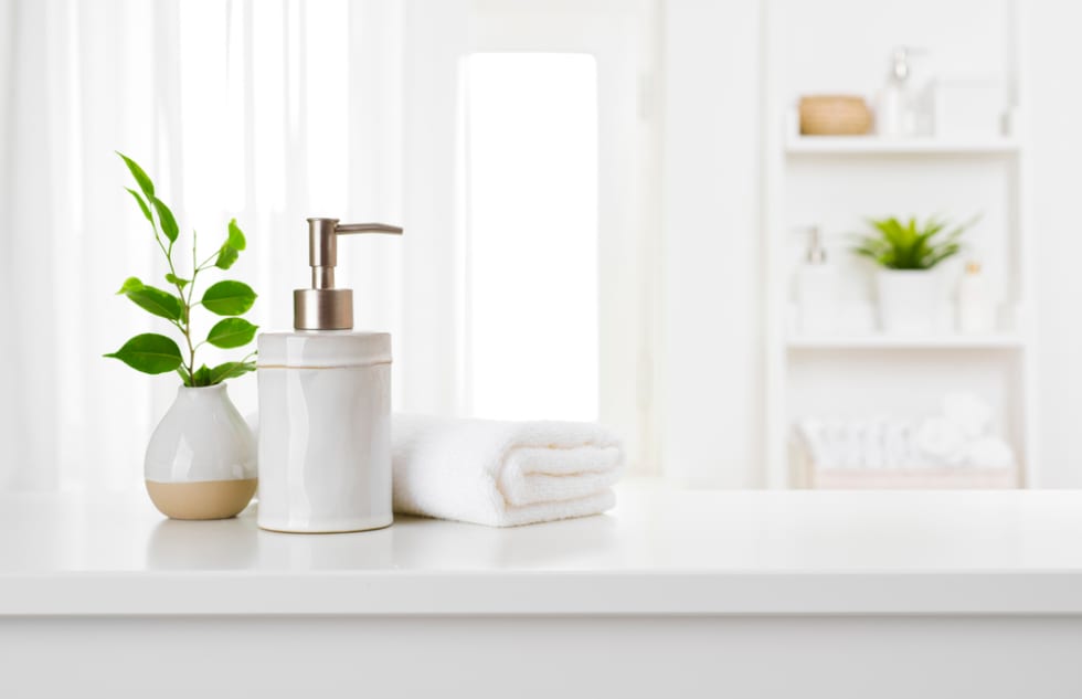 Soap dispenser and spa towel on pastel bathroom window interiorSoap dispenser and spa towel on pastel bathroom window interior