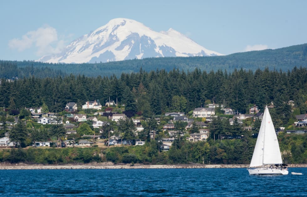  A photo of Mount Baker with a sailboat and houses in the Bellingham town area.