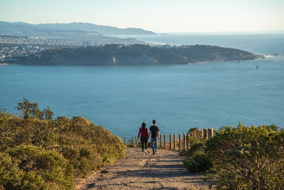 man and woman walking on the top of the mountain at San Francisco city, California.