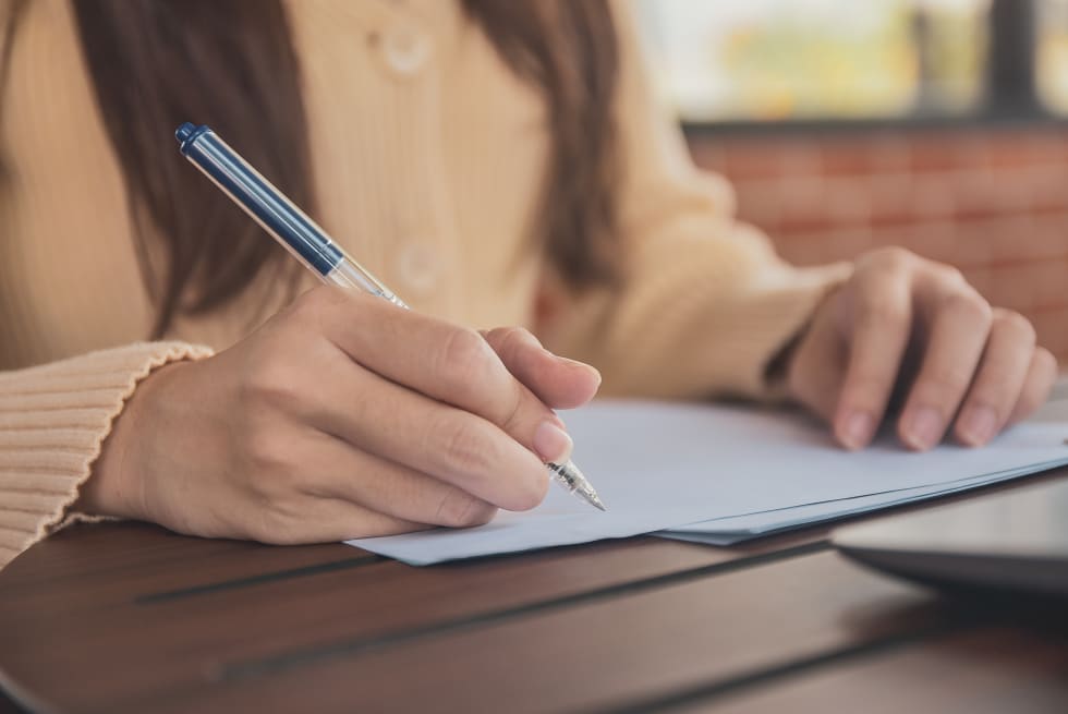 Close up hand writing on document business women working from home
