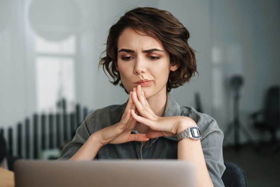 Young woman thinking of questions after a self-guided apartment tour