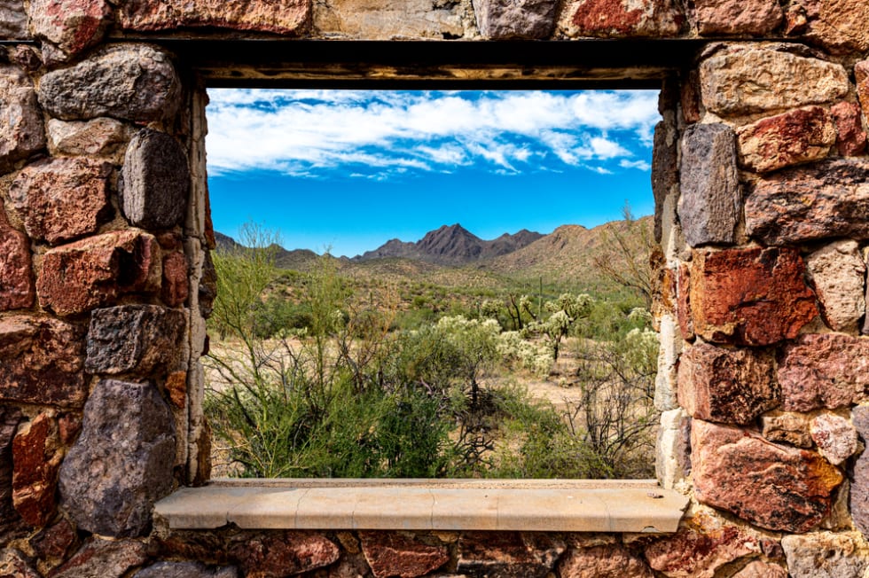  Looking through the window at the picturesque desert landscape from the ruins of a stone house on the Bowen Trail in Tucson Arizona.