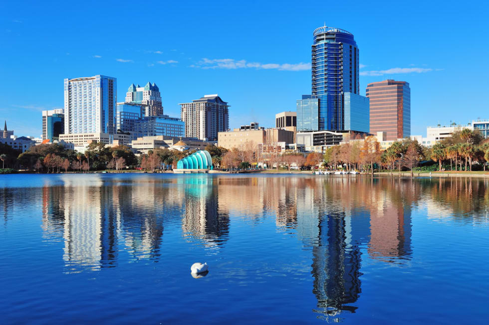 Orlando Lake Eola in the morning with urban skyscrapers and clear blue sky with swan.