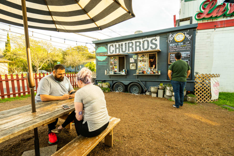 People eat at a local food truck called Austin Churro Co. in east Austin, Texas. The food truck a wide variety of delicious desserts