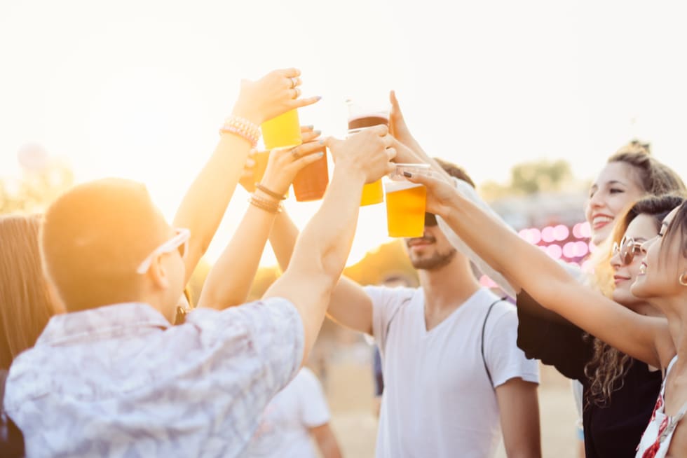 Friends drinking beer and having fun at music festival. Cheers