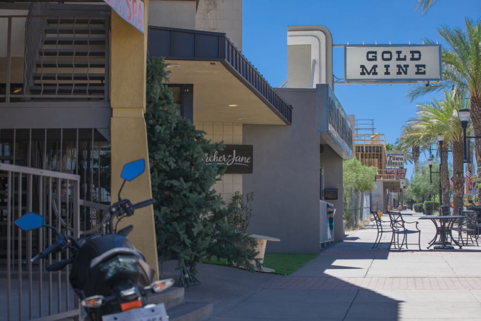 Water Street District, a historic area full of local and family owned businesses in Southern Nevada. A defocused motorcycle on the left. Beautiful day with blue sky.