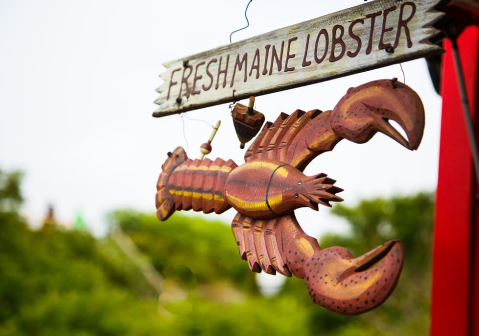 A wood hand painted and carved sign advertising fresh Maine lobster
