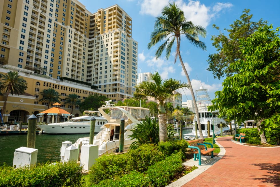 Fort Lauderdale, Florida - March 20, 2018: Cityscape view of the popular Las Olas Riverwalk downtown district along the promenade with yachts and condo building.