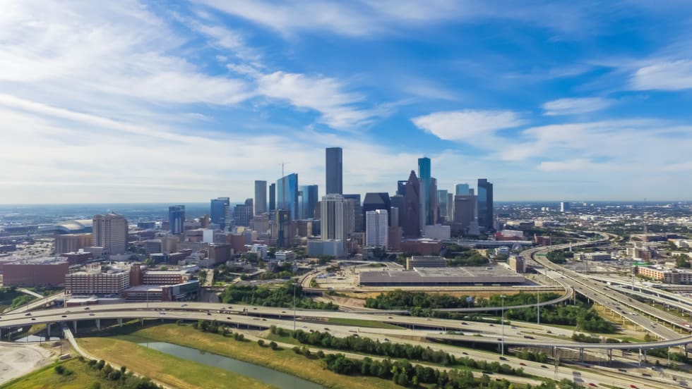 Aerial view downtown and interstate 45 and 69 highway intersection, massive intersection, stack interchange and elevated road junction overpass at sunset from the southeast side of Houston, Texas, USA