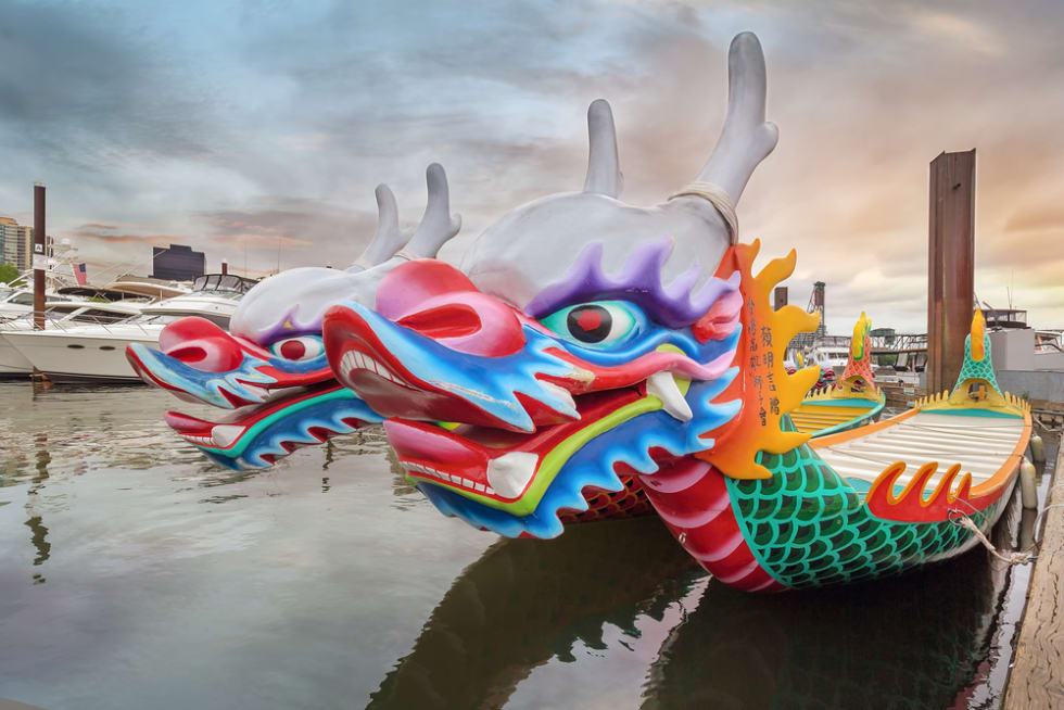 Chinese Dragon Boats at Willamette River in Portland OR at Sunset during Rose Festival Dragon Boat Race. It has been a Chinese tradition in Portland for 26 years.