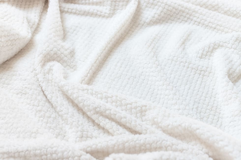 Beige delicate soft background of plush fabric.