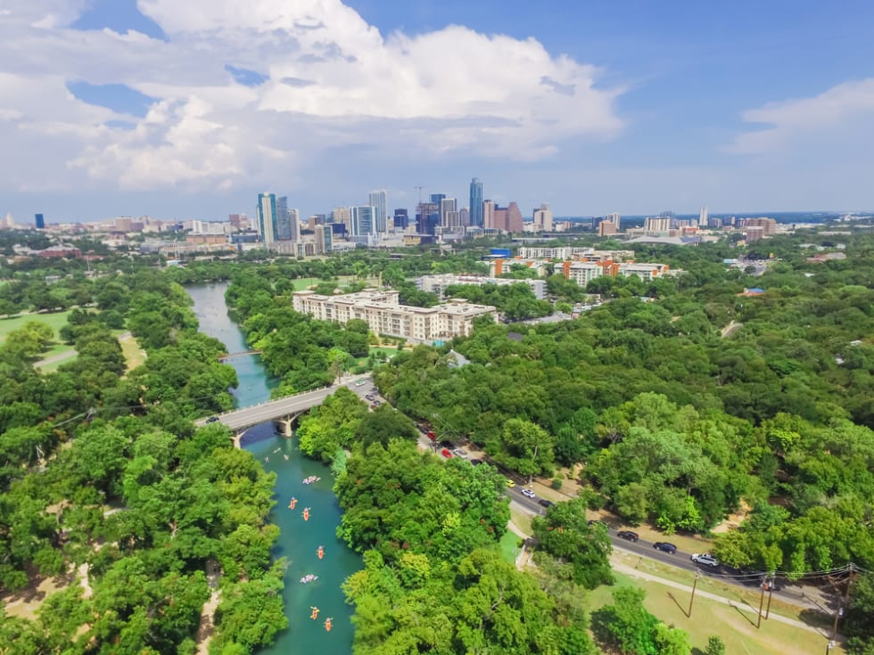  Aerial view Downtown from Barton Creek in Greenbelt at Zilker Metropolitan Park south Austin with summer blue cloud sky. Located at eastern edge of Hill Country, Austin the state capital of Texas, US.