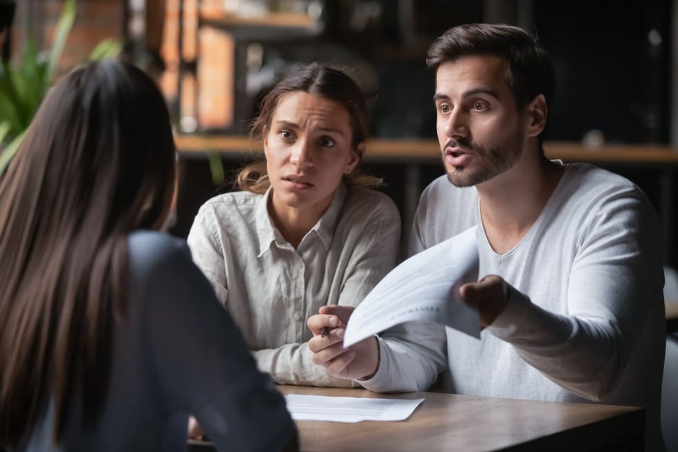 Annoyed angry disappointed customers clients couple holding paper arguing with bank manager fight complain on bad contract terms - rent reduction letter