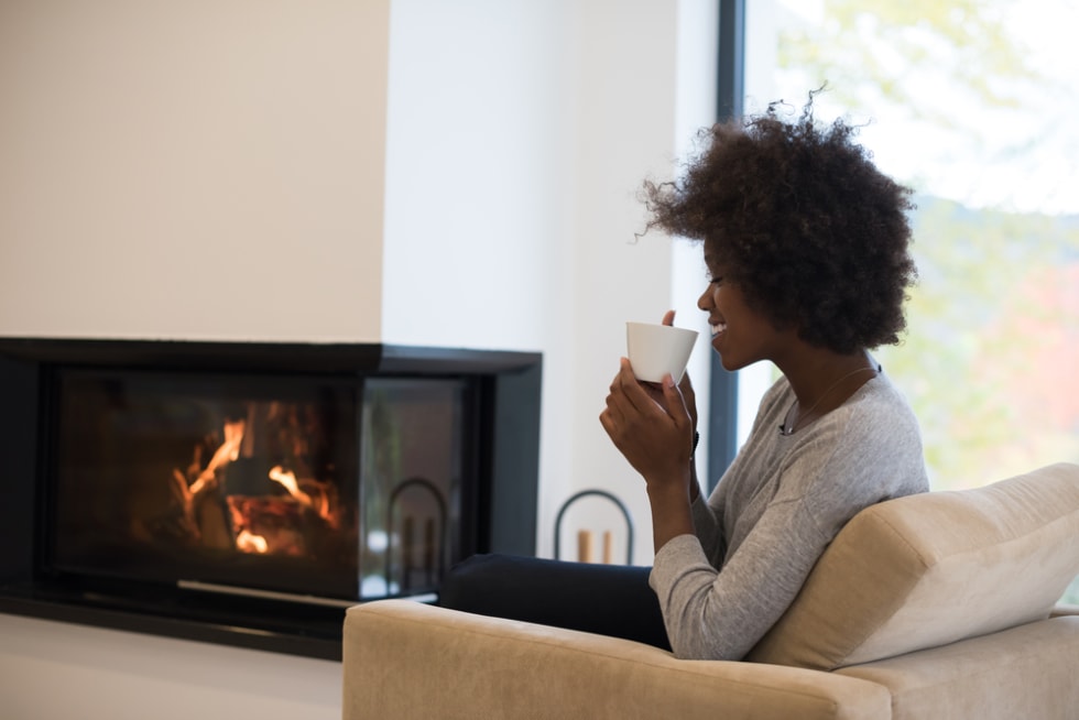 Woman relaxing by the fireplace