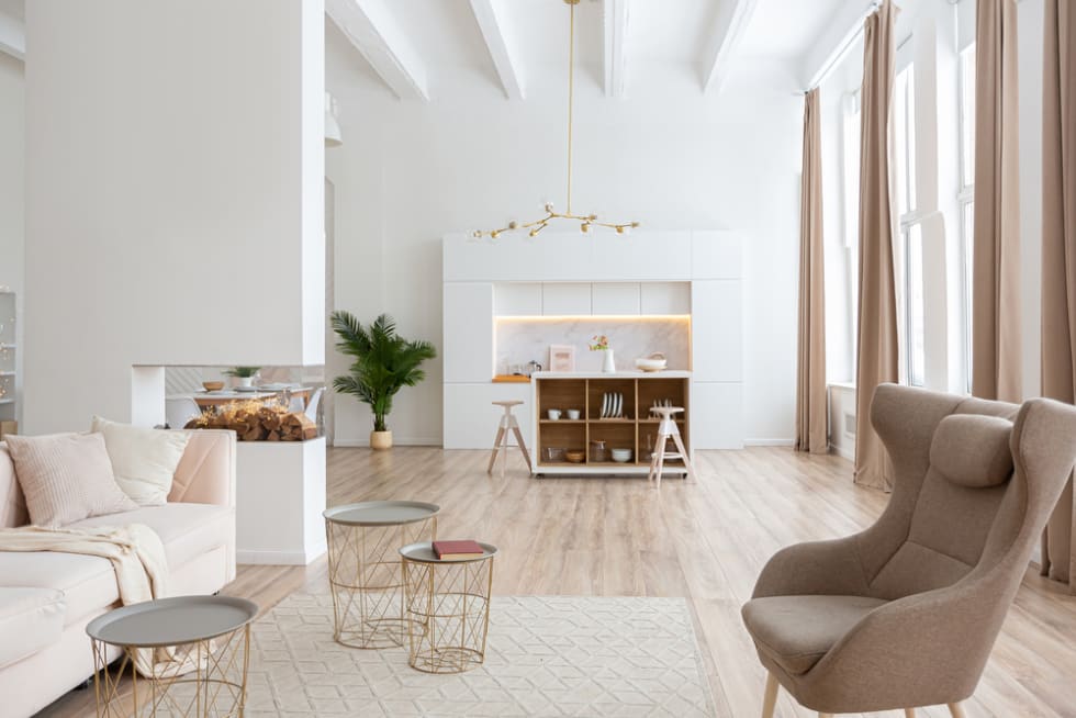 interior design spacious bright studio apartment in Scandinavian style and warm pastel white and beige colors. trendy furniture in the living area and modern details in the kitchen area.