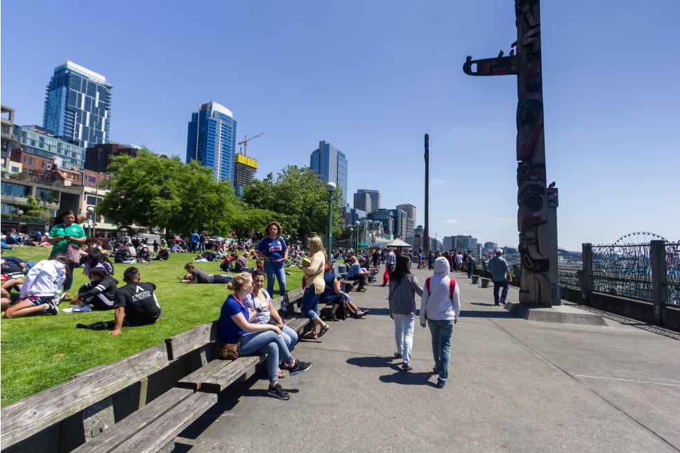 Crowd in Victor Steinbrueck park with cityscape background, Seattle, Washington, USA - cost of living in seattle