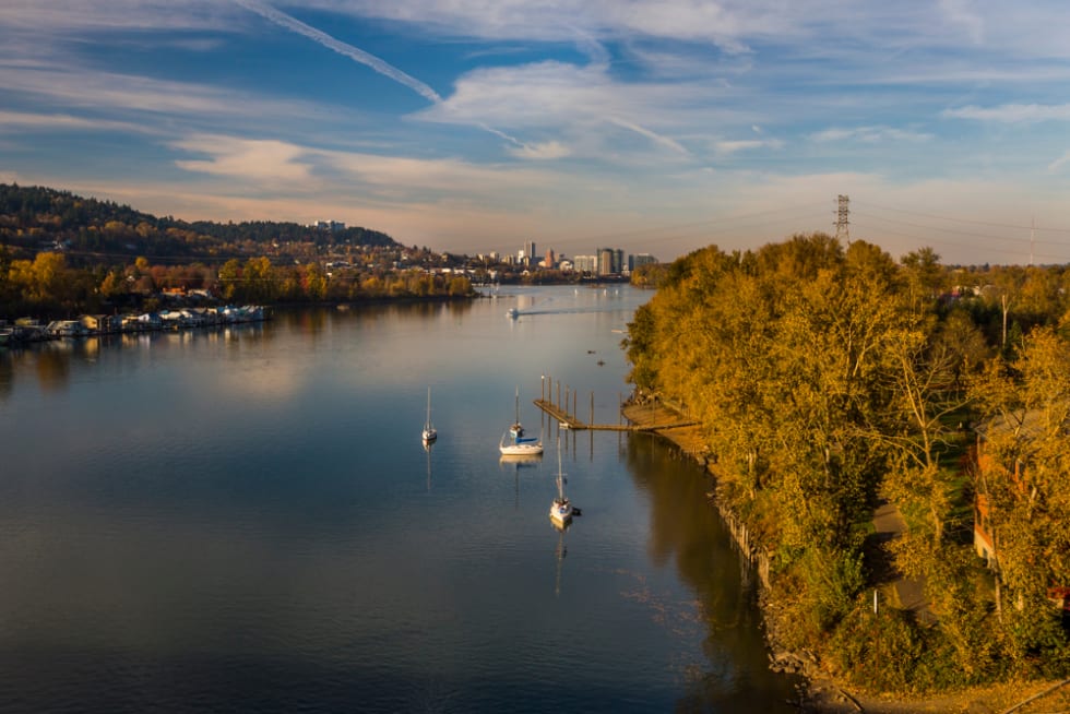 Landscape with river and urban area on background. Willamette river in Oregon in Milwaukie area. Portland cityscape on background