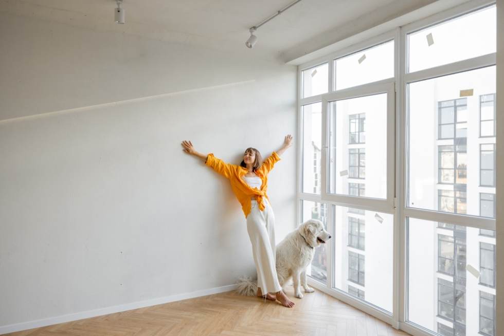Woman standing with dog in new apartment