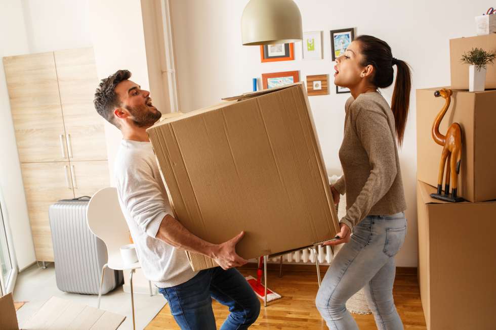 Young couple carrying big cardboard box at new home.Moving house - how to find sublets