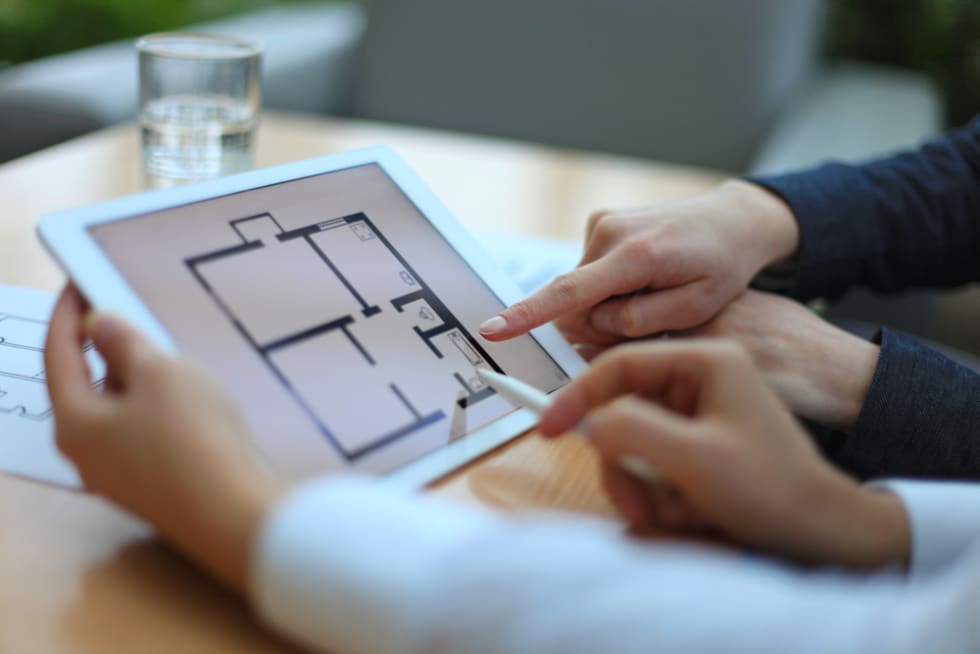 Real-estate agent showing house plans on electronic tablet
