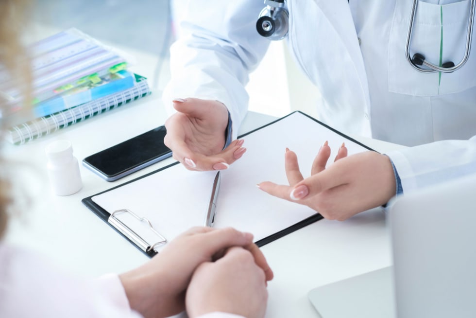 Patient listening intently to a female doctor explaining patient symptoms or asking a question as they discuss together in a consultation