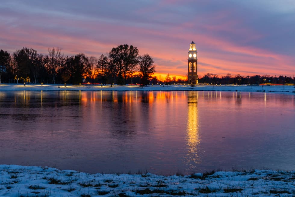  Bell tower and lake at Coxhall Garden in Carmel Indiana at sunset after snow in the winter of 2019