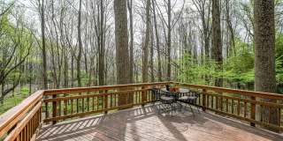 Welcome home! One of a kind, strikingly designed 2-level hillside chalet built on 1 1/2 acres of wooded property with stream surrounded by park land. Gallery 14