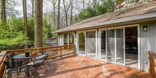 Welcome home! One of a kind, strikingly designed 2-level hillside chalet built on 1 1/2 acres of wooded property with stream surrounded by park land. Gallery 13