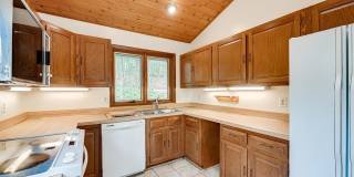 Welcome home! One of a kind, strikingly designed 2-level hillside chalet built on 1 1/2 acres of wooded property with stream surrounded by park land. Gallery 15