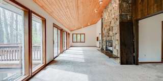 Welcome home! One of a kind, strikingly designed 2-level hillside chalet built on 1 1/2 acres of wooded property with stream surrounded by park land. Gallery 7