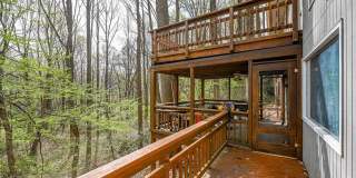 Welcome home! One of a kind, strikingly designed 2-level hillside chalet built on 1 1/2 acres of wooded property with stream surrounded by park land. Gallery 32