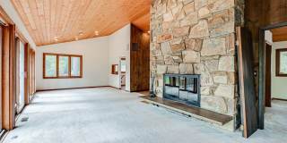 Welcome home! One of a kind, strikingly designed 2-level hillside chalet built on 1 1/2 acres of wooded property with stream surrounded by park land. Gallery 8