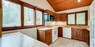 Welcome home! One of a kind, strikingly designed 2-level hillside chalet built on 1 1/2 acres of wooded property with stream surrounded by park land. Gallery 17