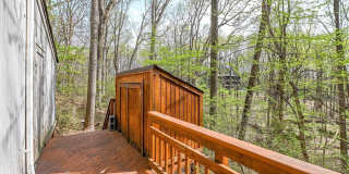 Welcome home! One of a kind, strikingly designed 2-level hillside chalet built on 1 1/2 acres of wooded property with stream surrounded by park land. Gallery 11