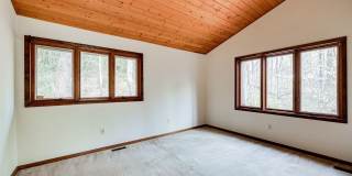 Welcome home! One of a kind, strikingly designed 2-level hillside chalet built on 1 1/2 acres of wooded property with stream surrounded by park land. Gallery 29