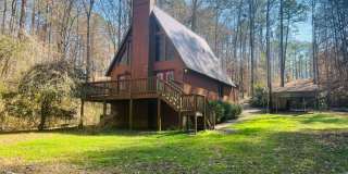Charming lake cabin featuring 3 bedrooms and 2 bathrooms with large open primary suite AND lake access! Must see! Gallery 1