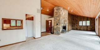 Welcome home! One of a kind, strikingly designed 2-level hillside chalet built on 1 1/2 acres of wooded property with stream surrounded by park land. Gallery 5