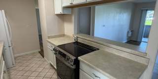 2BR/1BA Lakeside ground floor condo with 1 car detached garage, 1 uncovered parking space & community pool. Gallery 8