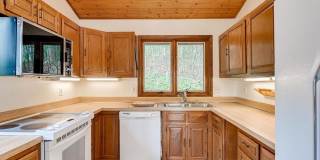 Welcome home! One of a kind, strikingly designed 2-level hillside chalet built on 1 1/2 acres of wooded property with stream surrounded by park land. Gallery 16