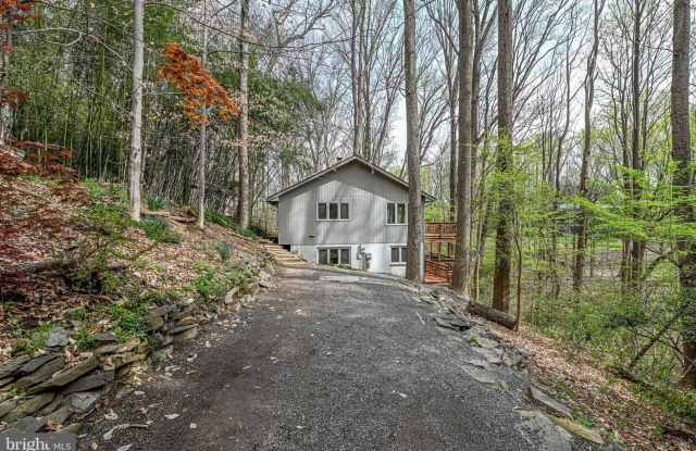 Welcome home! One of a kind, strikingly designed 2-level hillside chalet built on 1 1/2 acres of wooded property with stream surrounded by park land. photos photos